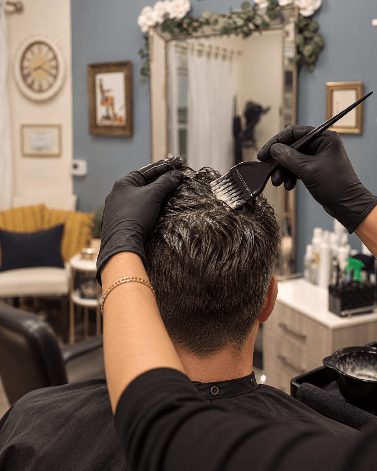 Close-up of color being applied to short men's hair with a small brush