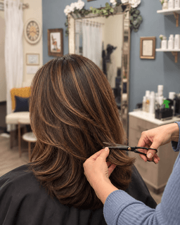 Stylist trimming freshly highlighted hair at Metropolitan Hair Boutique