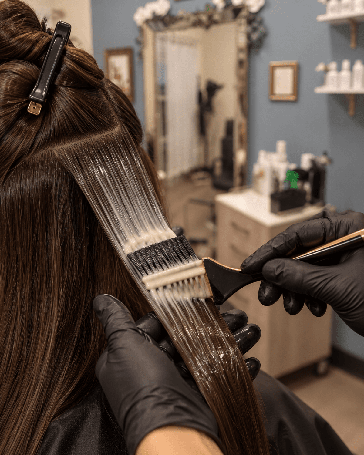 Keratin smoothing treatment being brushed through a sectioned length of hair