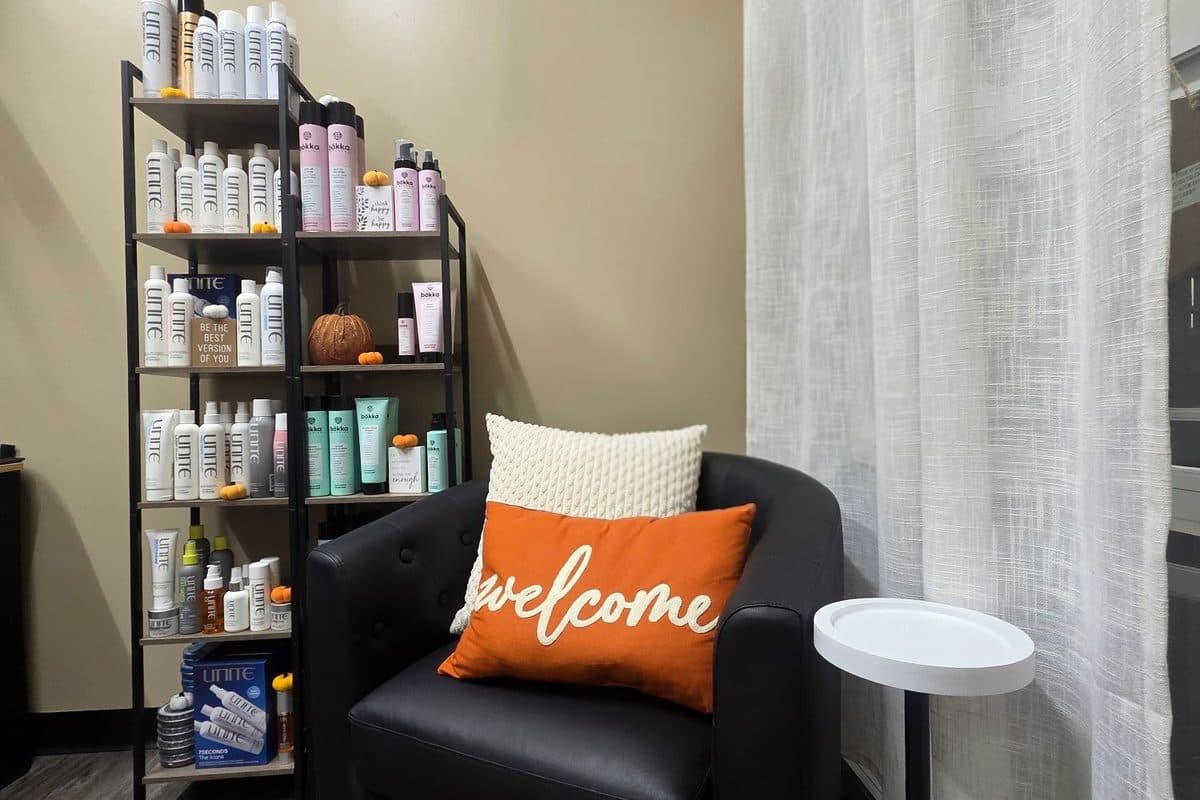 Welcome seating area with a leather chair and retail shelves